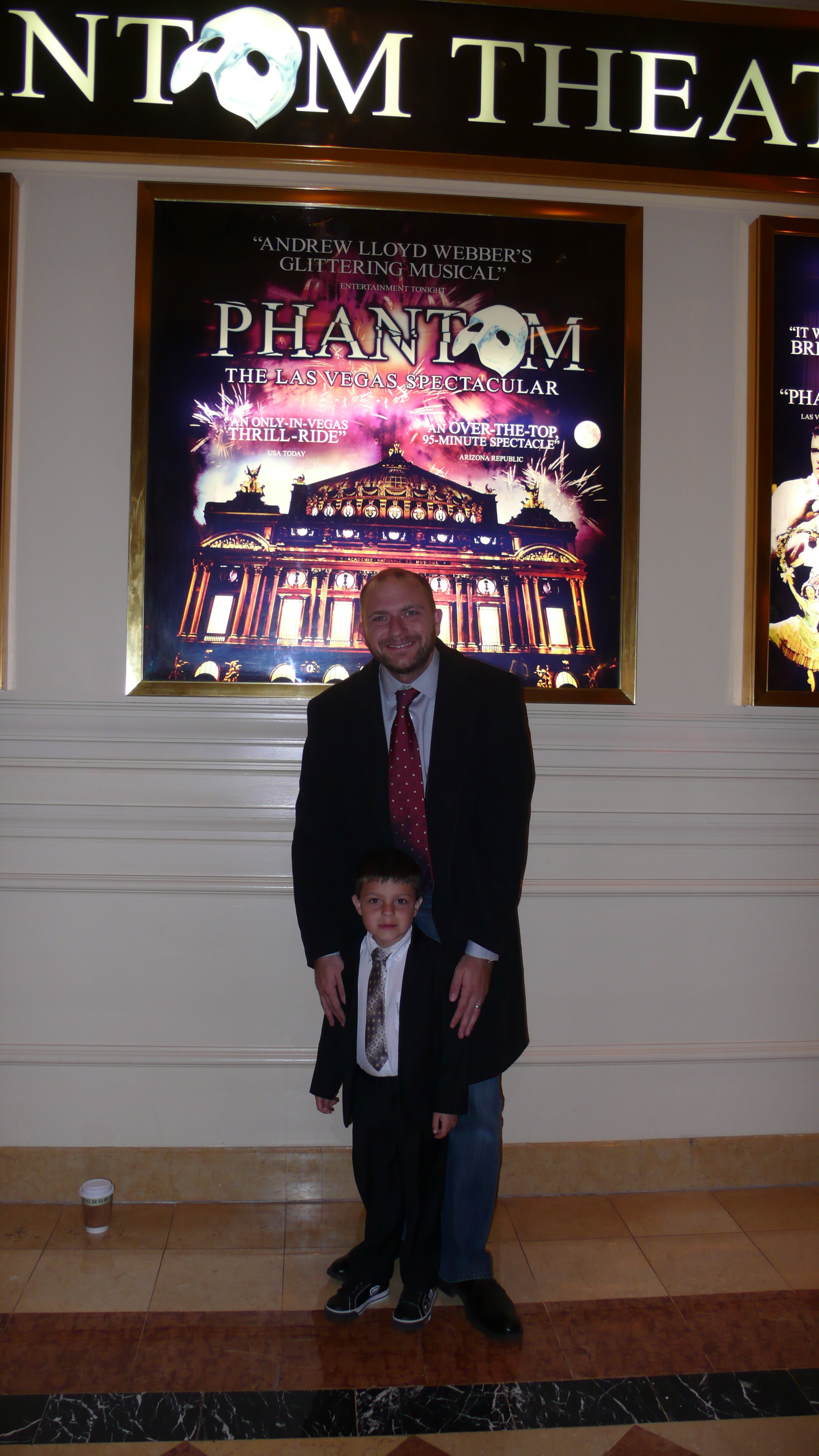 A childhood photo of Samo dressed up at the Phantom theater with an older man.