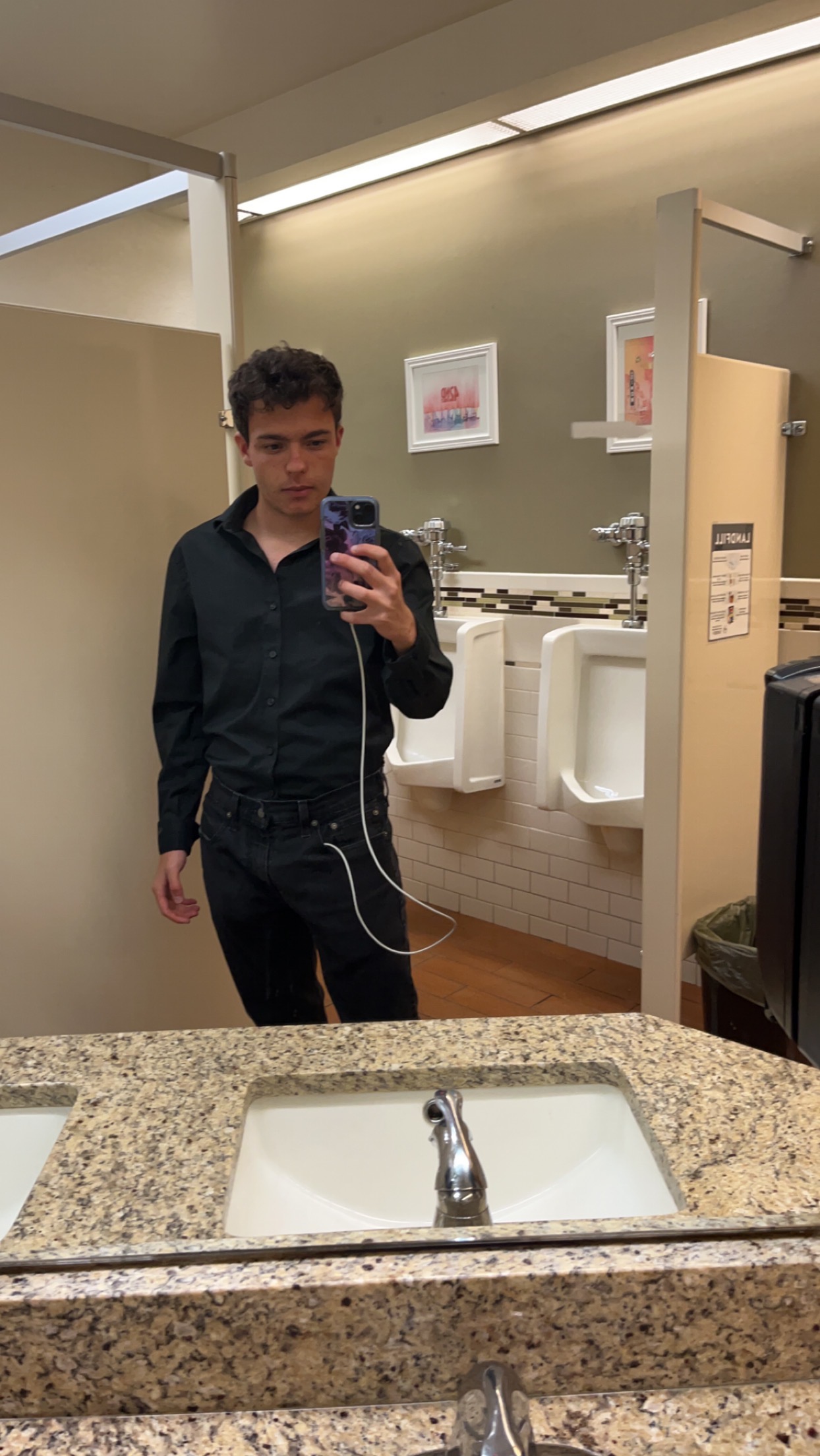 A portrait of Samo in a black outfit, photographed in a mirror.